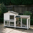 White wooden rabbit hutch with run and ramp on a garden patio - wrenwood hero