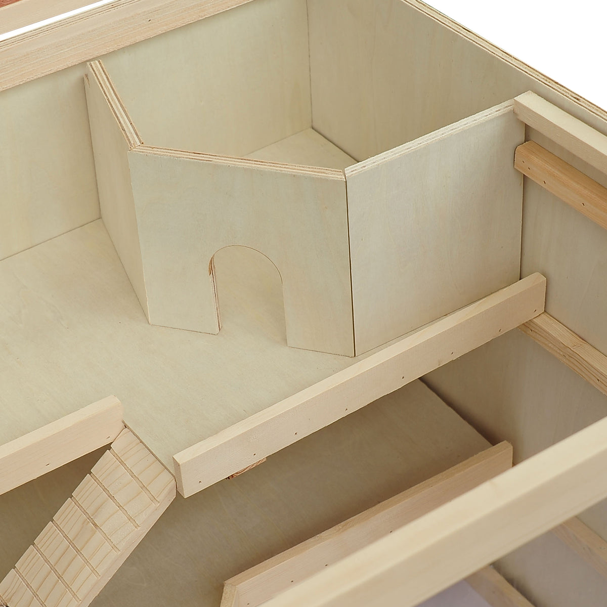 Close-up inside the cream wooden hamster cage showing an arched doorway in a divider and a ramp