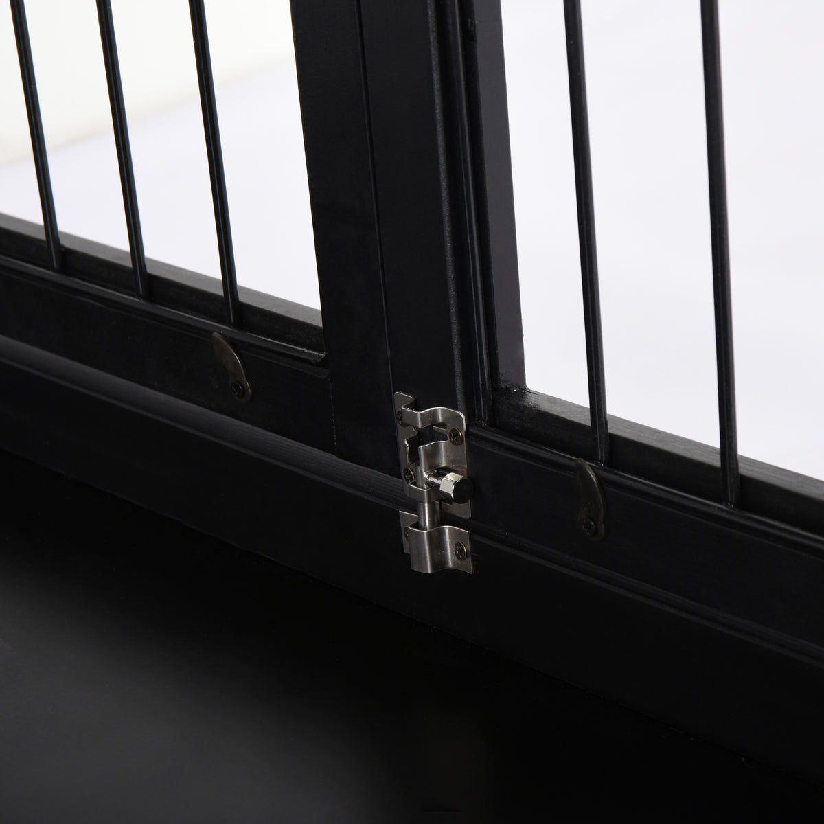 Close-up of the black crate end table's door hinge and latch against a bright window