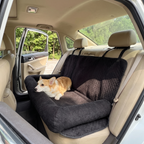 Black quilted pet car travel bed on a car back seat with a small dog sitting on it - wrenwood hero
