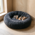 Dark grey plush donut cuddler pet bed in a living room - wrenwood hero