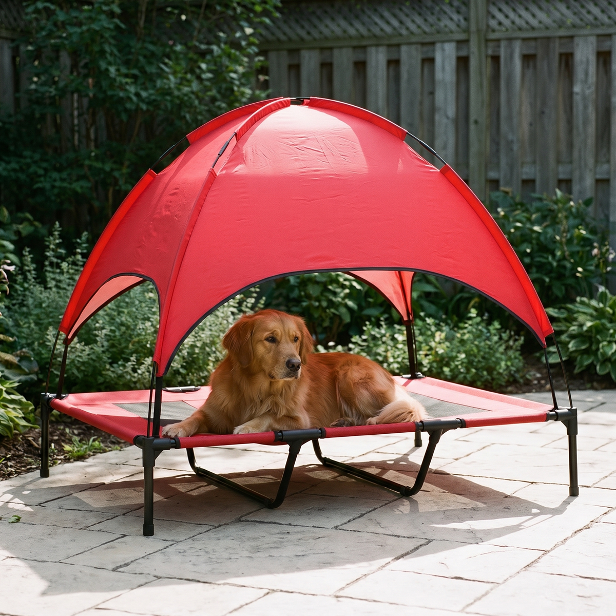 Elevated mesh dog cot with a red canopy shade in a backyard with a dog resting on it - wrenwood hero