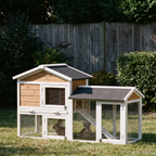 Two-tier white and natural wood rabbit hutch with side run in a backyard garden - wrenwood hero