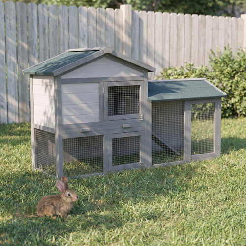 Large grey two-storey wooden rabbit hutch with run in a backyard garden - wrenwood hero