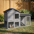 Gray wooden outdoor rabbit hutch with run and ramp on backyard grass - wrenwood hero