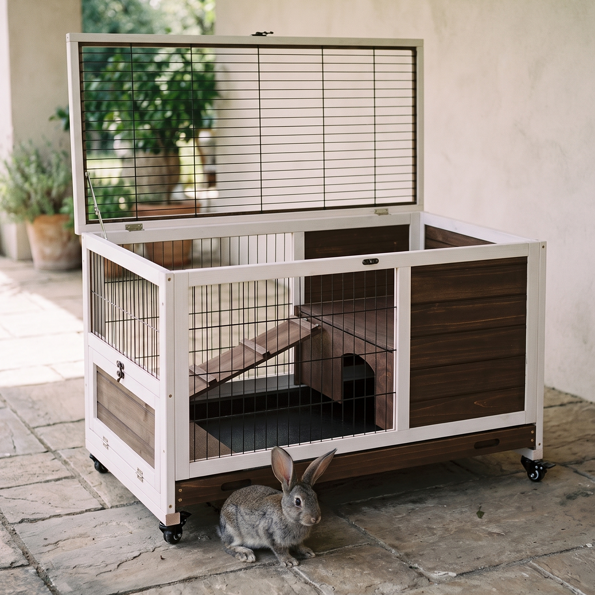Rolling wooden rabbit cage with pull-out tray and run on a patio - wrenwood hero