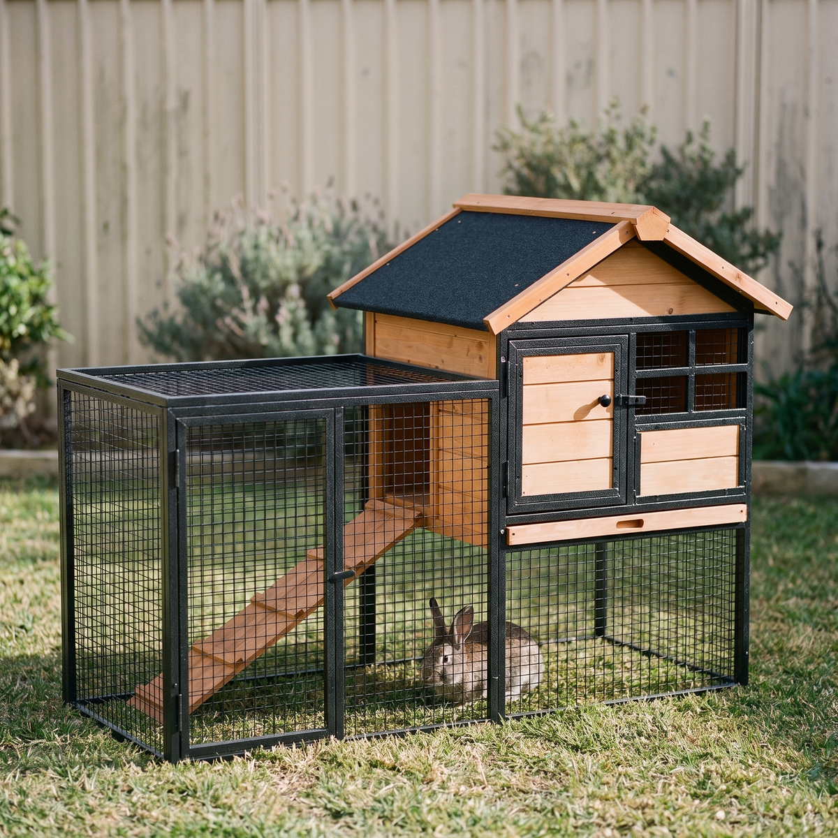 Elevated two level wooden rabbit hutch with weatherproof roof and run in a backyard - wrenwood hero
