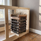 Wooden slatted hay feeder rack mounted on a hutch panel - wrenwood hero