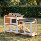 Two-tier outdoor wooden rabbit hutch with asphalt roof and run on a lawn, rabbit inside - wrenwood hero