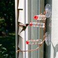 Copper window hummingbird feeder with a hummingbird feeding - wrenwood hero