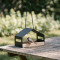 Hanging metal garden bird feeder with a chickadee on the seed tray - wrenwood hero