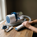 Cordless pet grooming vacuum kit with hose, clipper handpiece and attachments on a table - wrenwood hero