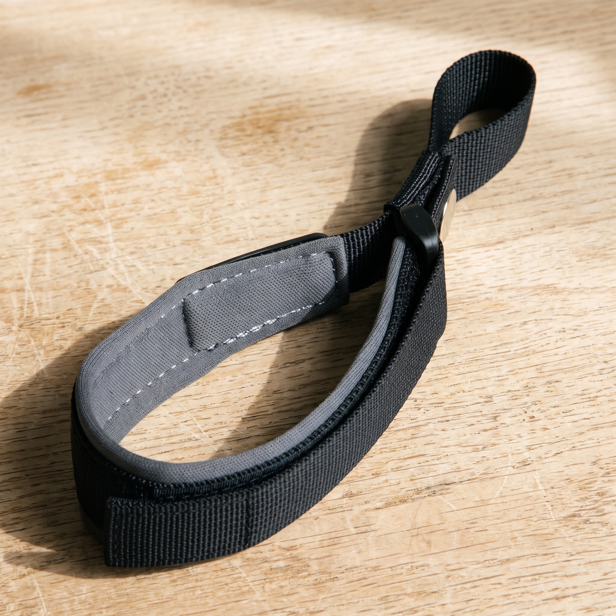 Hands-free padded nylon dog walking wrist strap on a wooden table - wrenwood hero