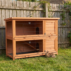 two-story wooden rabbit hutch on backyard grass - wrenwood hero v2