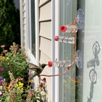 Hummingbird drinking at the copper window feeder by a garden window - wrenwood ugc lifestyle v2