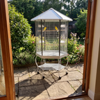 Canaries in the portable hexagonal bird aviary in a garden corner - wrenwood ugc lifestyle v2