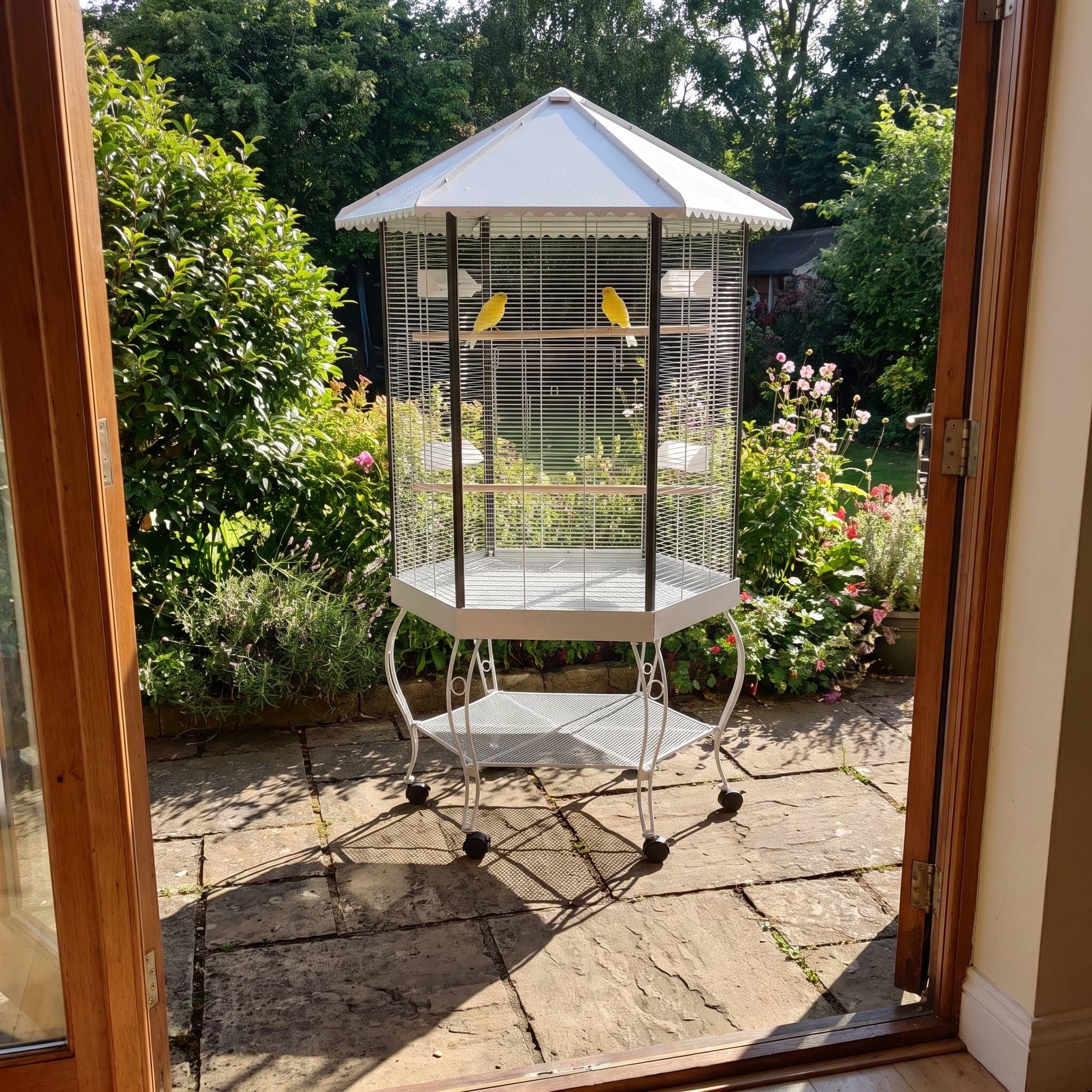 Canaries in the portable hexagonal bird aviary in a garden corner - wrenwood ugc lifestyle v2