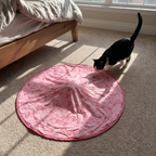 Tuxedo cat stalking the hidden bump under the pink fabric cover in a bedroom - wrenwood ugc lifestyle v2