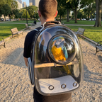 Owner from behind wearing the black parrot travel backpack with a macaw inside at the park - wrenwood ugc lifestyle v2
