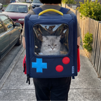 Dark blue retro console cat backpack worn on an owner's back along a neighborhood sidewalk, cat peeking through the window - wrenwood ugc lifestyle v2