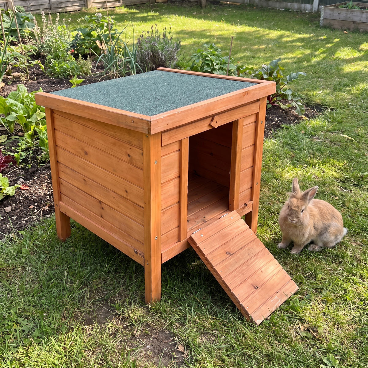 Wooden rabbit hutch with honey wood body and green roof in a backyard garden with a rabbit - wrenwood hero v2