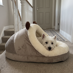 Side view of the slipper cuddler pet bed on an upstairs landing with a west highland terrier resting inside