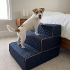 Terrier climbing the navy plush 3-step pet stairs beside a bed in a tidy bedroom